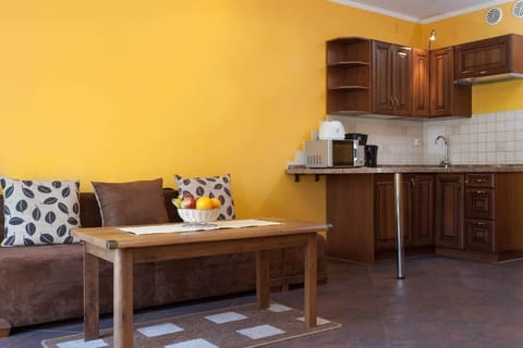 A close-up of the dining table, adjacent to the living room area. A brown sofa with patterned pillows adds comfort and style to the space.