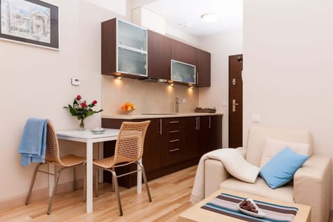 Another view of the kitchen area with dark cabinets and stainless steel appliances. The space feels compact yet functional.