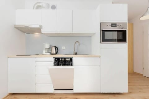 Functional kitchenette with white furniture and appliances.