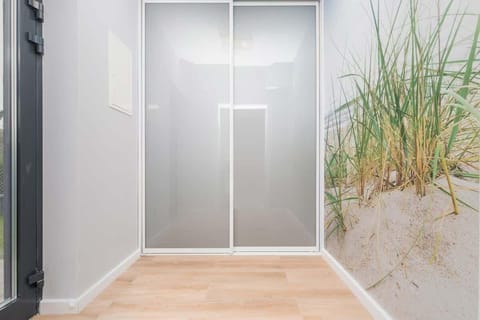 A bright hallway with a large wardrobe and light wooden floors and access to many rooms, creating a welcoming transition area in the house.