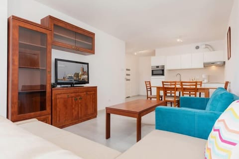 Bright, spacious living room with sofa beds and TV.