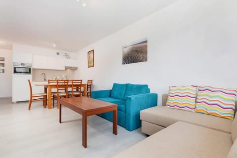 Bright living room space combined with kitchenette.