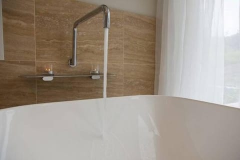 Bathtub, rainfall showerhead, eco-friendly toiletries, hair dryer