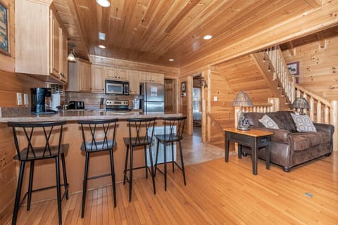 Seamless flow. A bird's eye view of the main floor showcases the bedroom, bathroom, kitchen, bar area, and staircase leading up to the second level.