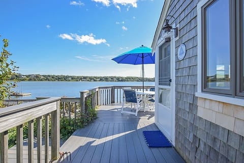 porch overlooking cove with table, chairs and umbrella and view of cove