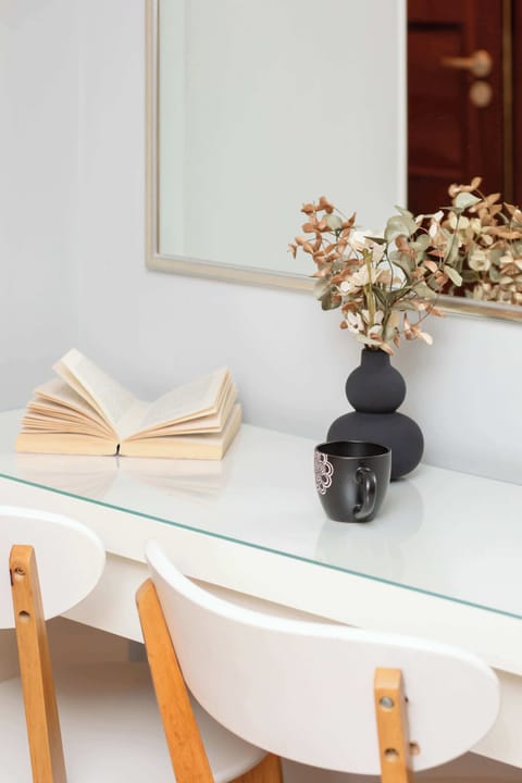 A simple dining area with a table, chairs, and decorative items such as vases and plates.