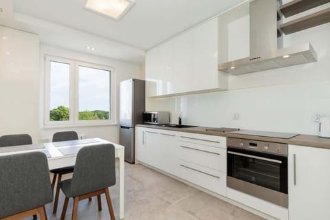 A kitchen area with white cabinets and a small breakfast nook, offering both cooking and dining spaces in one.