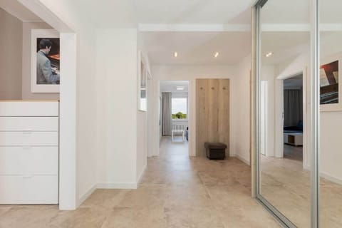 A hallway area with a large mirrored closet, adding storage space and visually expanding the area.