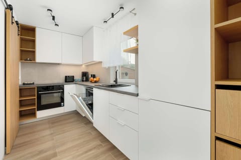 The spacious kitchen with bright cabinetry and wooden accents combines functionality with elegance.