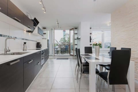 A modern kitchen with black and white cabinetry, a spacious countertop, and an open-plan layout.