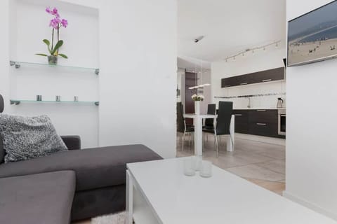 Another angle of a similar living room with a sofa, coffee table, and a large TV