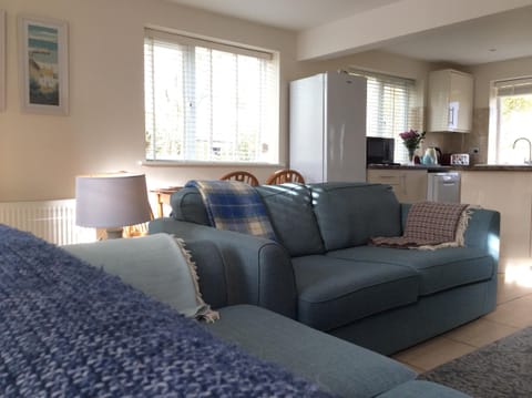 View from sitting area to open plan well equipped kitchen