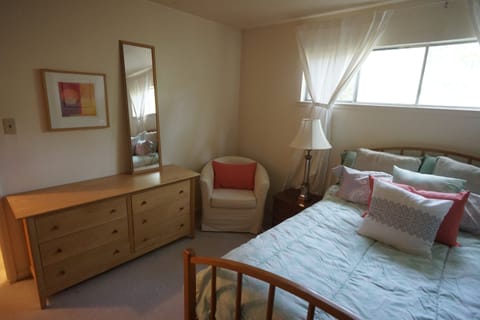 Bedroom has plenty of storage space, an armchair and large mirror.