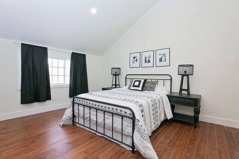 Chic bedroom with a modern metal bedframe, cozy linens, and minimalist decor.