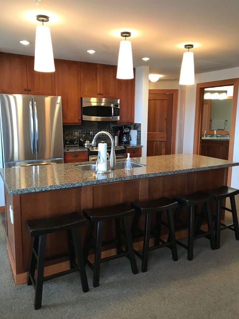Fully equipped gourmet kitchen with stainless steel appliances and large bar.