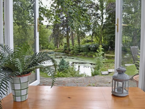 Conservatory in the grounds with lake view | Ivy Cottage, Drefach Felindre, near Newcastle Emlyn