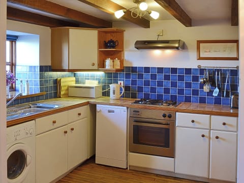 The contemporary half tiled kitchen is fited with up to date appliances to make mealtimes a pleasure, not a chore | Coachmans Cottage, White Cross, near Newquay