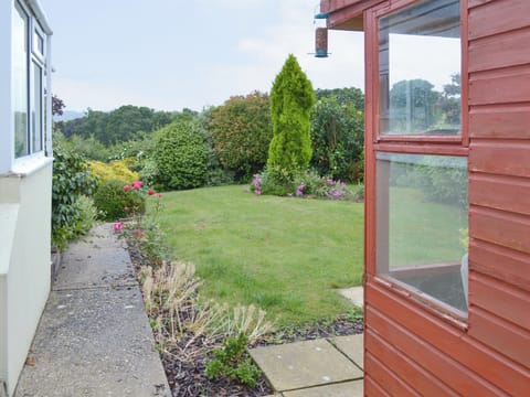 Lawned area front and rear. Rear garden is pet secure with summerhouse containing garden furniture - sufficient room to store cycles. | Dart Corner, Bovey Tracey