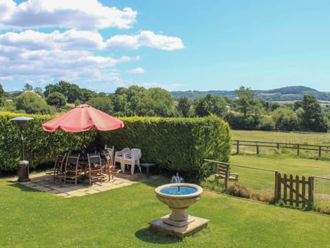 Garden with BBQ, fountain, views, play area and table, chairs and umbrella | Stable Cottage, Colyford, near Seaton