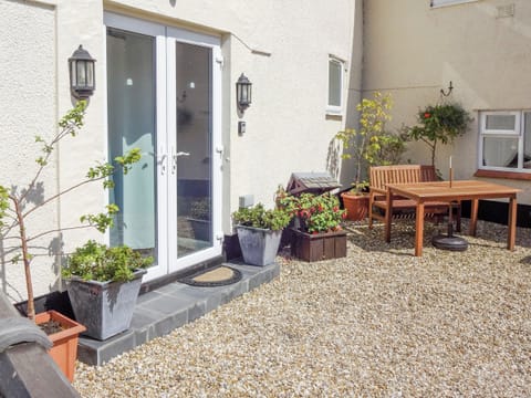Gravelled courtyard with outdoor furniture | The Snug - Ty Copr, Pen-y-Sarn, near Amlwch