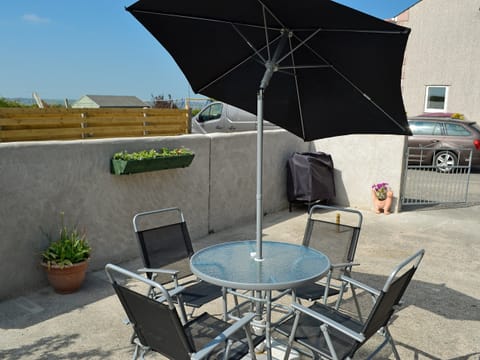 Outdoor sitting/dining area | Ty Main Cottage, Newborough, near Llangefni