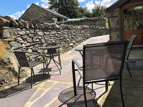 Paved patio with table and chairs | Ysgubor, Tregarth, near Bangor