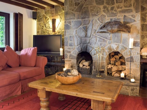 Living area with open fire and exposed stone fireplace | Sardis Cottage, near Kilgetty