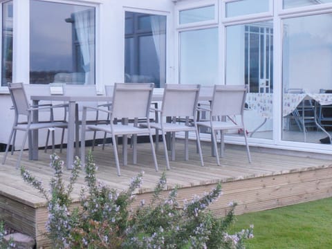 Decked area with table and chairs by the conservatory | Rosehill, Paignton