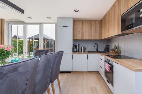 A bright kitchen-dining space with a modern wooden dining table set with turquoise plates and glasses, perfect for a family meal.