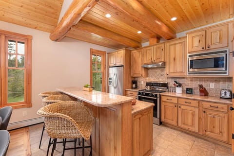 Fully equipped, high-end kitchen with three seats at the breakfast bar