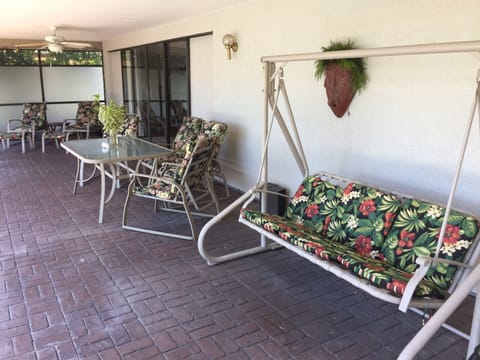 Relaxing porch swing, outdoor seating for 6 within covered portion of lanai.