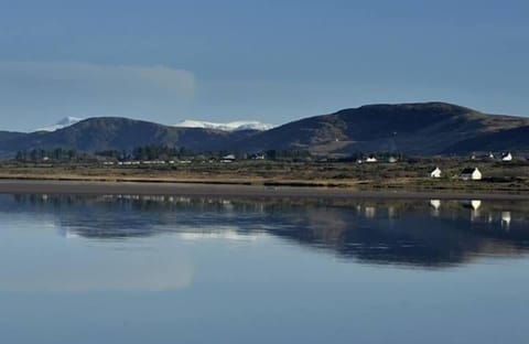 Snow capped mountain reflection on beach at Waterville