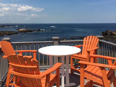 Second floor ocean front deck with adirondack chair seating.