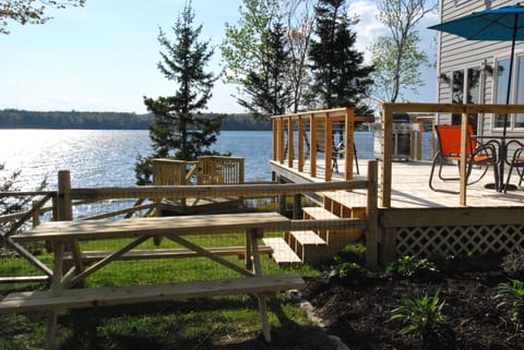 Deck with grill, seating, steps to fenced yard, steps to shore, picnic table
