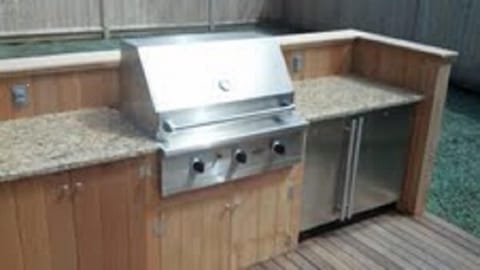 The outdoor Viking commercial grill, fridge and ice maker with granite counter.
