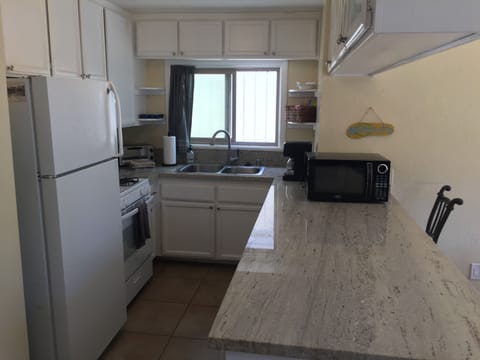 Kitchen area with counter, seats 3 people. Dining table adjacent but not shown.