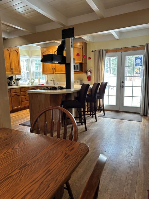 Area connecting dining area with kitchen with french doors leading to the deck