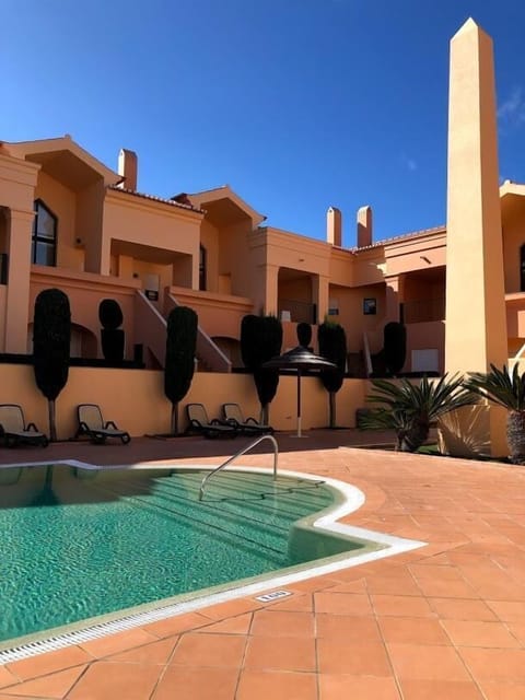 Heated adult pool, sun loungers and communal pool terrace area.