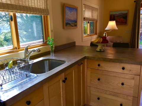 Lovely custom kitchen with Cement counter. Stove/oven. Coffee machine. Toaster.