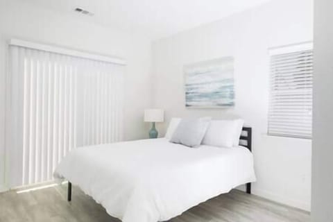 Bedroom 1 with sliding door to shared patio, offering peaceful views of olive orchard and trees.