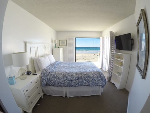 Master Bedroom overlooking ocean with blue print bedspread