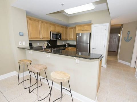Granite counter tops and breakfast bar with 3 stools.
