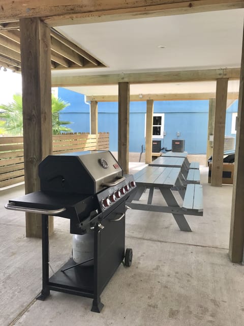 Shared grill and picnic tables area under house