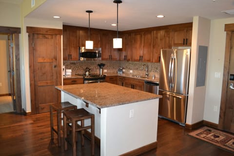 Fully-stocked gourmet kitchen with granite counters, stainless steel appliances.
