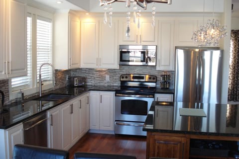 Kitchen with custom cabinetry granite counters and stainless appliances