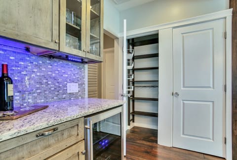 Kitchen features large pantry closet & bar area with LED lighting,  drink fridge