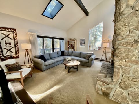 Living room, wood burning fireplace, open concept, high ceilings, natural light