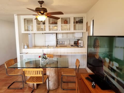 Standing in front of living room furnishings looking to the kitchen