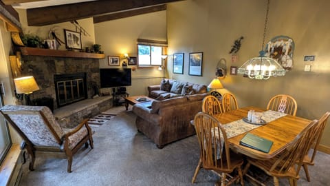 Living room with sofa bed, wood fireplace, and dining table