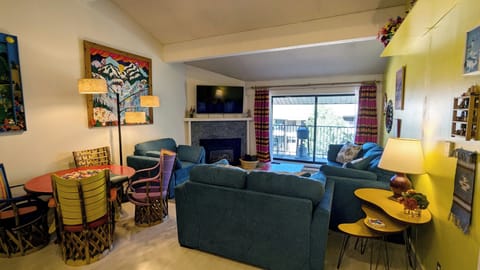 Living room with sofa bed, gas fireplace, dining table, and balcony w/ gas BBQ